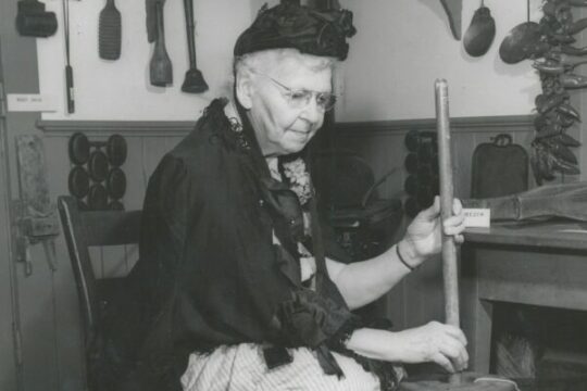 Mrs Ethel Stewart with a butter churn in historic costume