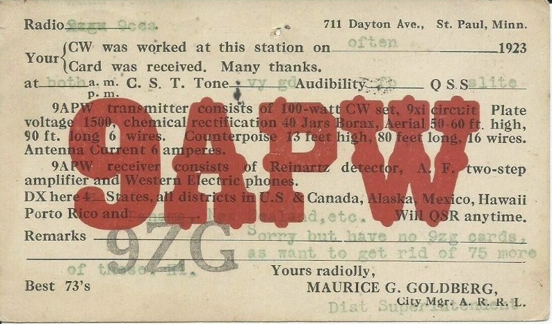 An old ham radio card shows typewriter printing in the background and a large red stamp of the acronym 9APW on top of the text.